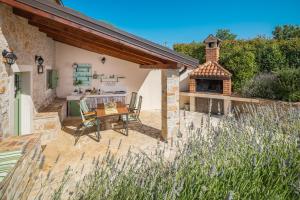 an outdoor patio with a table and a fireplace at Villa Nonni-romantic stone house in Višnjan