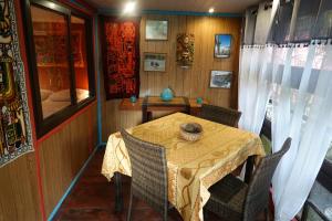 a dining room with a table and chairs in a house at Gîte et meublés du Tour du monde in Dumbéa