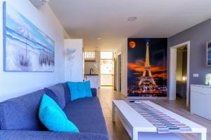 a living room with a blue couch and the eiffel tower at La Cascada 202 in Puerto Rico de Gran Canaria