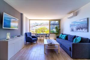 a living room with a blue couch and a table at La Cascada 202 in Puerto Rico de Gran Canaria