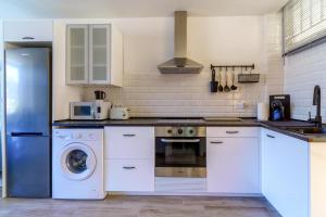 a kitchen with a refrigerator and a washing machine at La Cascada 202 in Puerto Rico de Gran Canaria