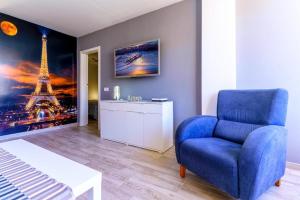 a living room with a blue chair and the eiffel tower at La Cascada 202 in Puerto Rico de Gran Canaria