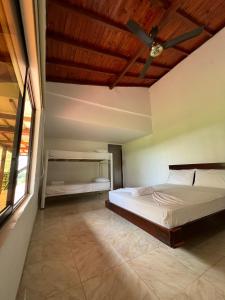 - une chambre avec un lit et un ventilateur de plafond dans l'établissement Finca Hotel Doradal, à Doradal