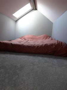 a bedroom with a red bed in a room at Studio à Theuville-Baigneaux in Theuville
