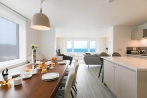 Carbis Bay的住宿－Golden Heights，一间厨房和客厅,客厅内配有木桌。