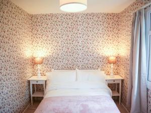 a bedroom with a bed and two tables with lamps at Henllys Lodge in Velindre-farchog