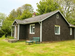 a small house with a green bench in the yard at Henllys Lodge in Velindre-farchog