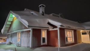 una casa cubierta de nieve por la noche en Apartment Seutu en Saariselka