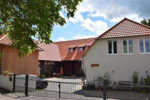 Biały dom z płotem przed nim w obiekcie Grundmühle - Kleines Ferienappartement auf dem Ponyhof 