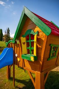 uma pequena casa de jogos de madeira num parque infantil em Green Hill em Ravna Gora