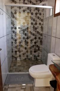a bathroom with a toilet and a shower at Pousada Refúgio do Sol in Cambará