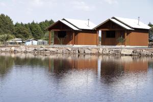 a building next to a large body of water at Pousada Refúgio do Sol in Cambara do Sul