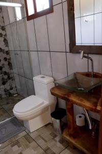 a bathroom with a toilet and a sink at Pousada Refúgio do Sol in Cambara do Sul