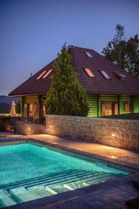 a house with a swimming pool in front of a house at Green Hill in Ravna Gora