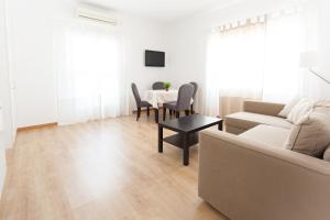 Apartamentos Diaber Laraña في إشبيلية: غرفة معيشة مع أريكة وطاولة