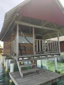 una casa con un banco en un muelle en el agua en Cabañas Waili en Niatupo