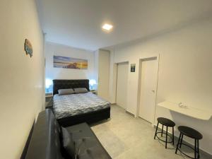 a bedroom with a bed and two stools in it at Kitnet Premium Canto do Forte - Praia Grande in Praia Grande