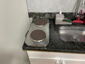 a kitchen counter with a stove and a sink at Kitnet Premium Canto do Forte - Praia Grande in Praia Grande +19 photos