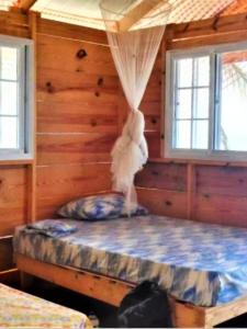 una camera con un letto in una baita di tronchi di Cabañas Waili a Niatupo