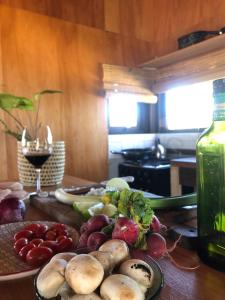 una mesa con un plato de verduras y una copa de vino en Casa Canela - se reserva con seña, en Punta del Diablo