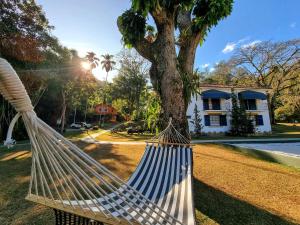 a hammock hanging from a tree in front of a house at Saison Resort & Spa in Itaipava