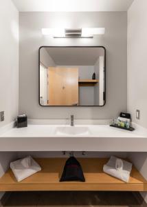 a bathroom with a sink and a mirror at The Warehouse Hotel at Champion Mill in Hamilton