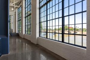 a hallway with large windows looking out at a river at The Warehouse Hotel at Champion Mill in Hamilton