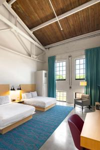 1 dormitorio con 2 camas y alfombra azul en The Warehouse Hotel at Champion Mill en Hamilton