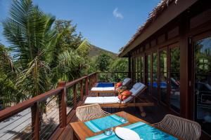 a deck with tables and chairs on a resort at The Hideout in Jost Van Dyke