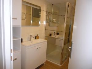 y baño con ducha acristalada y lavamanos. en LES RIVES DE LA DIVE les chambres 123 coaching, en Moncontour-de-Poitou