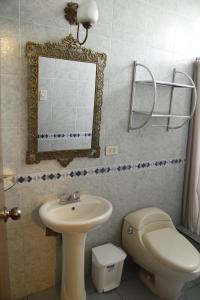 y baño con lavabo, aseo y espejo. en Casablanca Lima en Lima