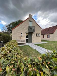 una casa de ladrillo con techo negro en Wellness Huisje 52, en Ewijk
