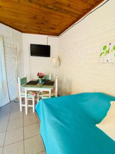 een kamer met een bed, een tafel en een tv bij Cabañas Julio Cesar in Cartagena