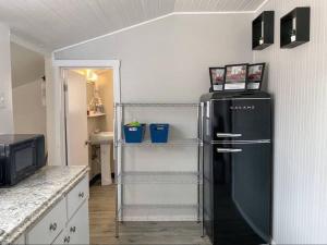 a kitchen with a black refrigerator in a room at Charming Bungalow 