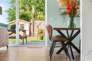 ein Esszimmer mit einem Tisch und einer Vase aus Blumen in der Unterkunft Beach & Forest Retreat -Domburg- in Oostkapelle