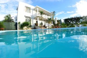 uma villa com piscina em frente a uma casa em Villa Osumare Guest House em Flic-en-Flac