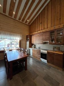 a kitchen with a wooden table and a kitchen with a stove at Levin Ruska B in Kittilä