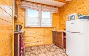 a kitchen with wooden walls and a refrigerator at Nice Home In Ustka-Przewloka With Wifi in Ustka