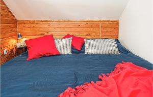 a bedroom with a blue bed with red pillows at Nice Home In Ustka-Przewloka With Wifi in Ustka