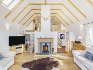 a living room with a fireplace and a tv at Askival in Elgol