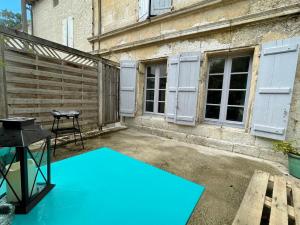 a patio with a blue mat and a grill at Le Tropical - Studio avec terrasse in Angoulême