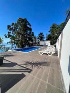 una terraza con tumbonas y una piscina en Villa Deluxe Kvariati, en Kvariati