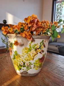 un jarrón lleno de flores sentado en una mesa en Pousada Candelabro, en Tiradentes