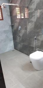 uma casa de banho com um WC branco e um chuveiro em Sri Krishna Palace em Mangalore