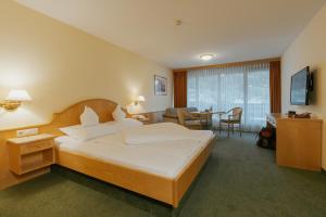 a hotel room with a bed and a dining room at Hotel Zimba in Schruns-Tschagguns