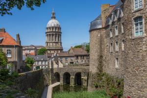 an old building with a cathedral in the background at Entre mer et falaises - Equihen - Maison familiale avec jardin à 800 m de la mer in Équihen-Plage