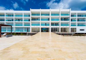 a large white building with benches in front of it at Marina Puerto Velero in Tubará