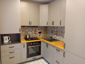 a kitchen with white cabinets and a stove at NEW apartment for RELAX in Uzhhorod