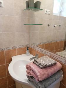 La salle de bains est pourvue d'un lavabo blanc et d'un miroir. dans l'établissement Teubel apartman 2, à Székesfehérvár