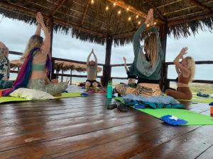 Un Dia Boutique Resort في بلاياس: مجموعة من النساء لممارسة اليوجا على الشاطئ